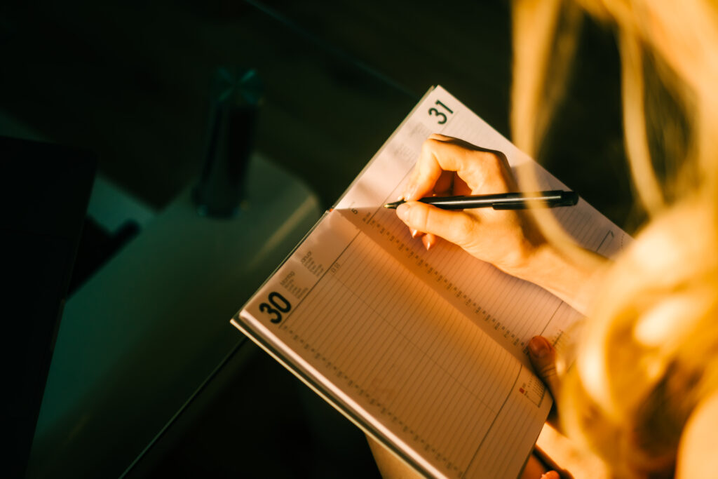 Caucasian woman making notes at home office.